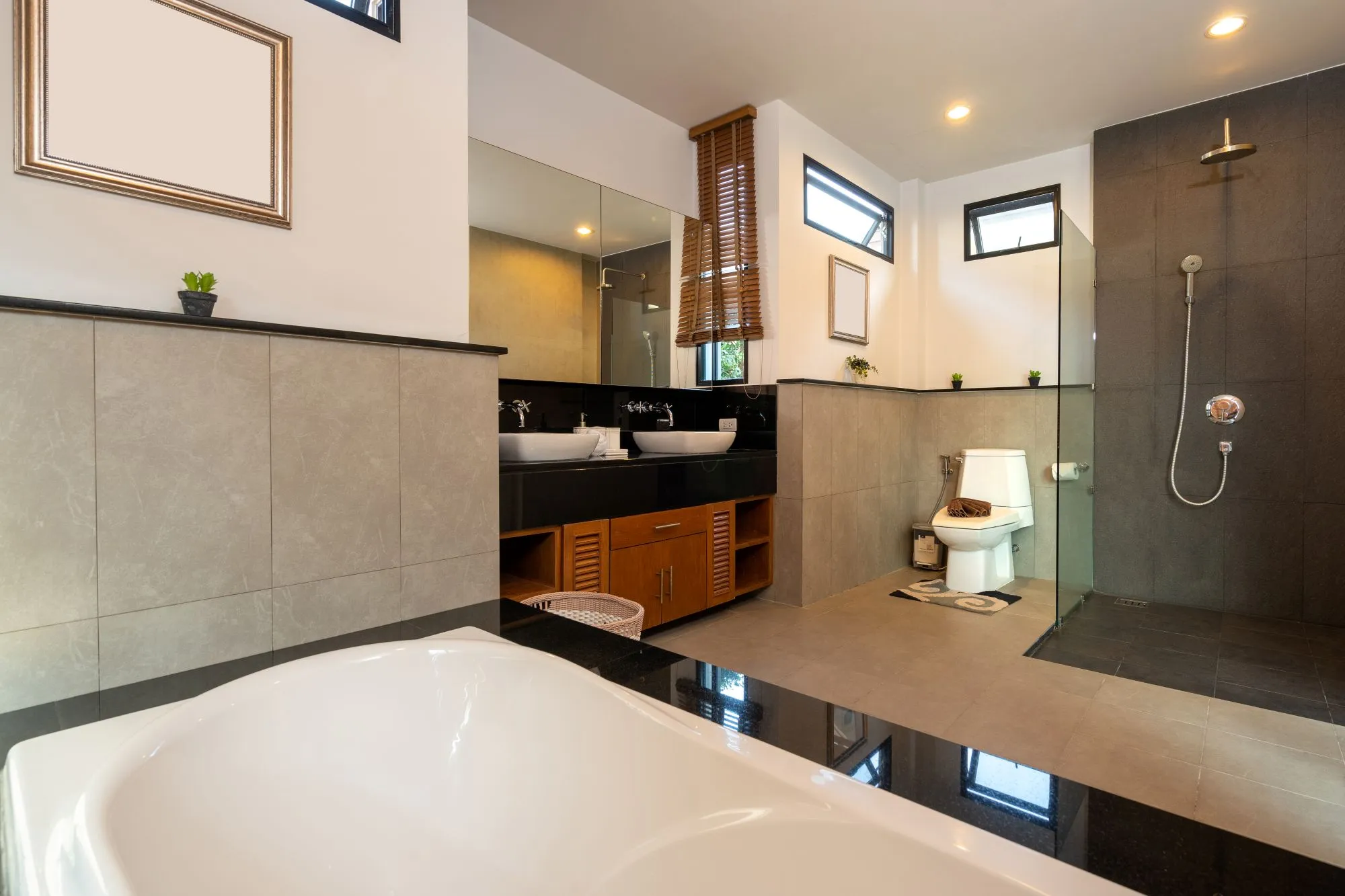 A modern bathroom remodel with double sinks, a soaking tub, and an open glass shower